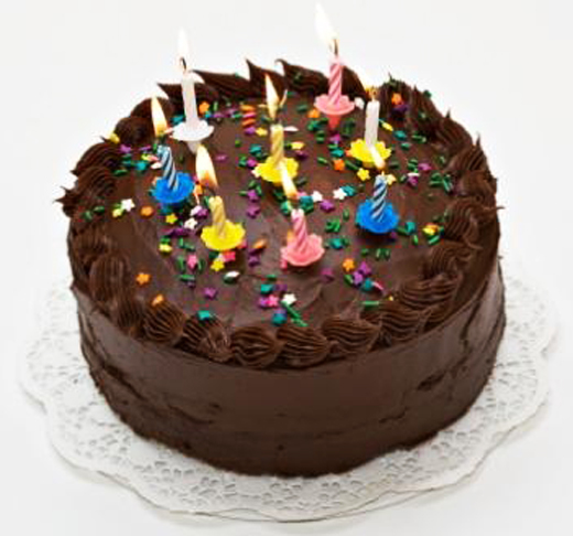 Chocolate-lover's birthday cake with lit candles.